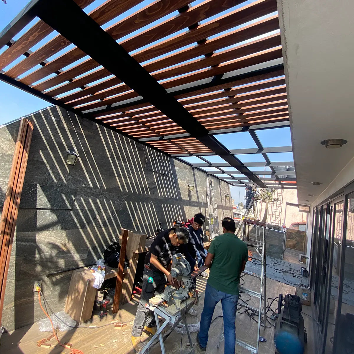 Proceso de instalación de pérgola en CDMX con técnicos validando estructura y anclajes; incluye garantía de 1 año