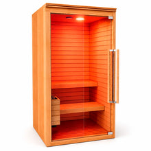 Sauna para 2 personas abierto con puerta de vidrio, detalle interior con bancas de madera y ambiente cálido de relajación.